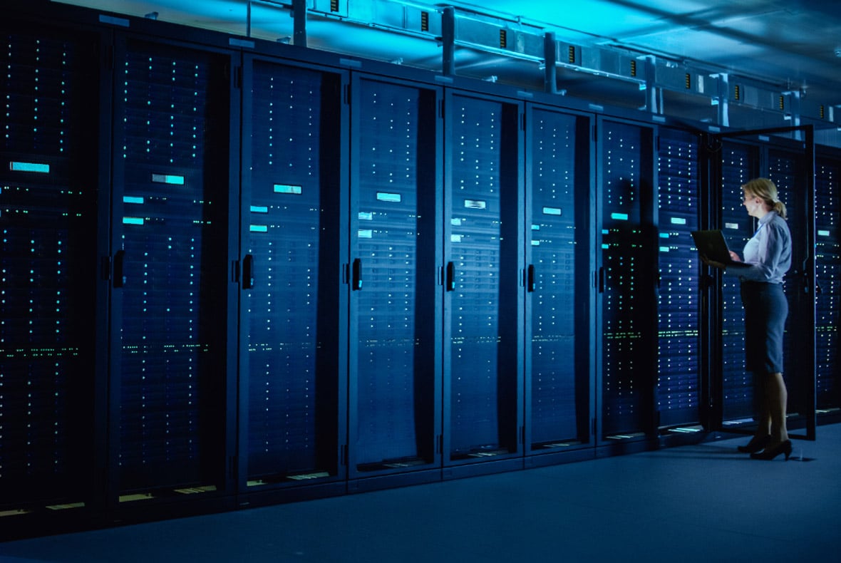 Data center with woman standing by with laptop
