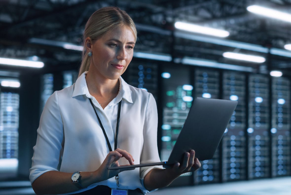Woman in data center working on laptop