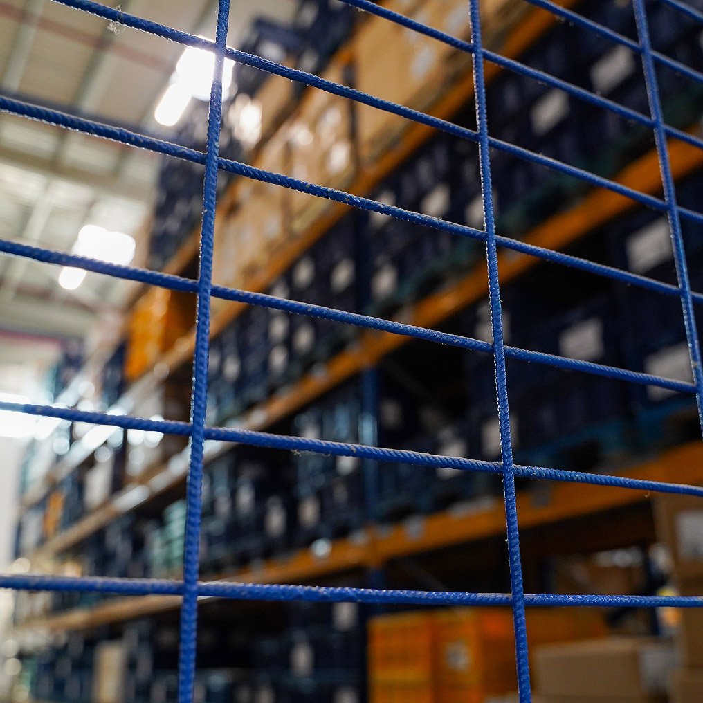 View through a security fence of goods held in a warehouse