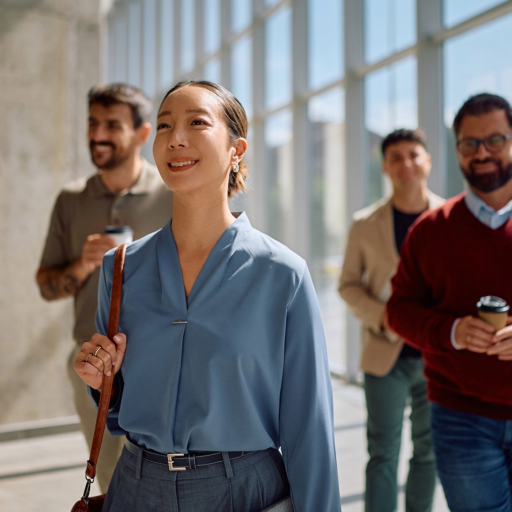 A diverse group of professionals walk through an office building