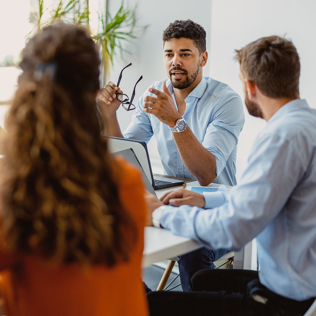 Three professionals gather around a small table